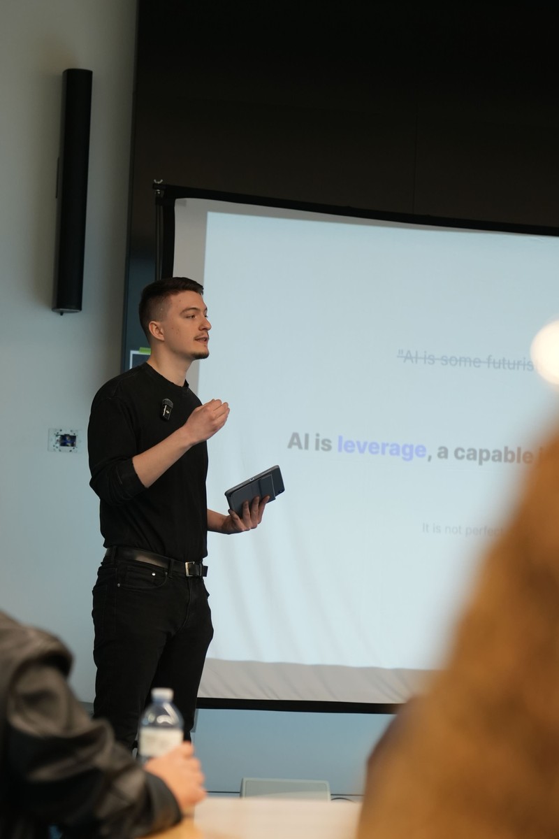 Dmytro speaking at the front of a room during a presentation